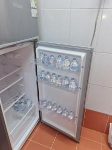 麦地那Ayser 1的装满大量水瓶的开放式冰箱