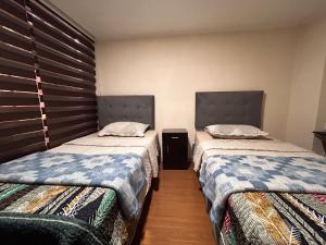 圣地亚哥Chez Humbert的两张睡床彼此相邻,位于一个房间里