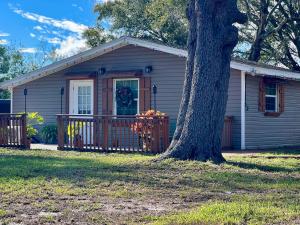 Lake AlfredThe Lake Alfred Citruswood Cabin的一个小房子,有门廊和一棵树