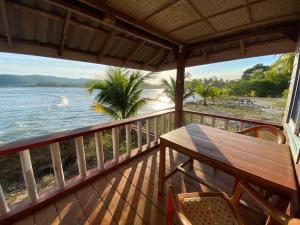 瓜隆岛Sok Sabay的阳台配有桌椅,享有水景。