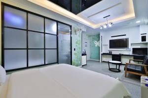 蔚山G&G Hotel的卧室配有一张白色大床和一张书桌