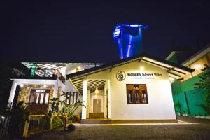 希克杜沃Monkey Island Hotel的一座在夜晚顶部有蓝色灯光的建筑