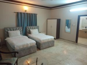 卡拉奇Bondi Beach Resort的客房设有两张床、一张桌子和镜子