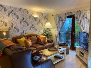 彭里斯Lake District cottage in 1 acre gardens off M6的带沙发和电视的客厅