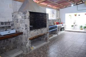 Ursulo GalvánEstancia Vacacional 20 Aguas的带厨房的客房内的大型石头壁炉
