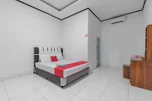 西洛瓦RedDoorz @ Geopark Ciletuh Sukabumi的一间白色客房内的床铺卧室