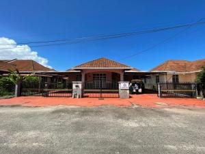 瓜拉丁加奴HOMESTAY IZHAN BANDAR KUALA TERENGGANU的前面有黑色围栏的房子