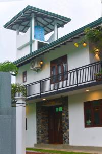 希克杜沃Monkey Island Hotel的白色的房子,上面设有阳台