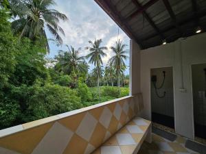 通萨拉Hao Norn Hostel的阳台享有棕榈树景色的浴室