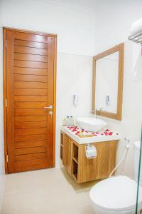 沙努尔Shanta Villa的一间带水槽、卫生间和镜子的浴室