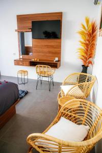 沙努尔Shanta Villa的一间卧室配有藤椅和平面电视