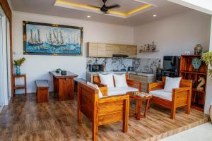 沙努尔Shanta Villa的客厅配有木制家具和墙上的绘画
