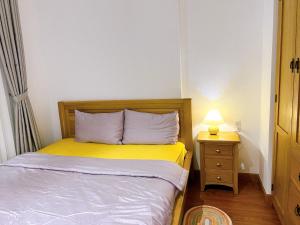 龙川市Lá Homestay Apartment的一间小卧室,配有一张床和床头灯