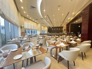 富查伊拉宜必思富查伊拉酒店的配有木桌和白色椅子的餐厅