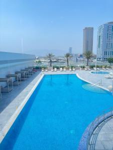 富查伊拉Aparthotel Adagio Fujairah的一座大型蓝色游泳池,位于一座建筑的顶部