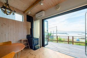 叶山町南葉山 - Seaside Cabin in Minami-hayama的一间设有桌子和大型滑动玻璃门的房间