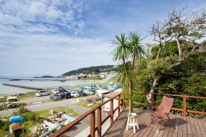 叶山町南葉山 - Seaside Cabin in Minami-hayama的阳台享有停泊车辆的码头景致。