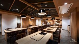 东京Daiwa Roynet Hotel Shimbashi的用餐室配有木桌和椅子