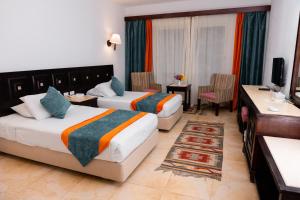 沙姆沙伊赫绿松石海滩酒店的酒店客房配有两张床和一张书桌