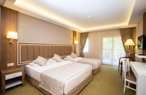 库萨达斯库斯图尔俱乐部全包式度假村的酒店客房配有两张床和一张书桌