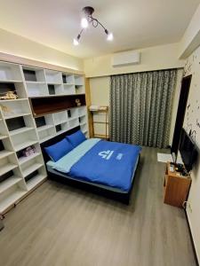 安平区1986 轻旅的一间卧室配有蓝色的床和书架