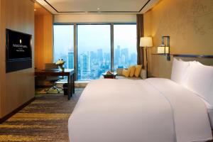 福州InterContinental Fuzhou的酒店客房设有一张大床和一张书桌。