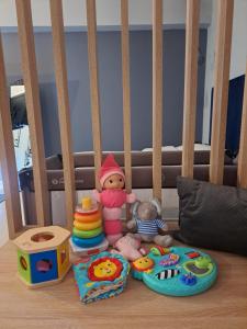 塞萨洛尼基marizas luxury suites #2的一张带玩具、娃娃和其他玩具的婴儿床