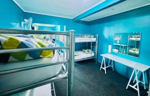 罗托鲁瓦Crashpalace Backpackers的蓝色客房配有两张双层床和一张书桌