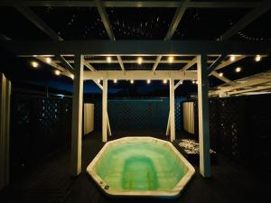 罗托鲁瓦Crashpalace Backpackers的甲板上的热水浴池(晚上)