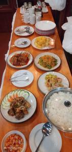 TapokrengRaflow Resort Raja Ampat的长桌,带食物和米饭的盘子
