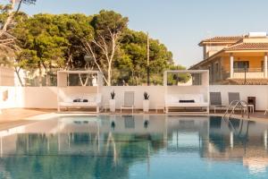 帕尔马海滩Hotel Principe Wellness&Spa的一个带白色椅子的游泳池和一个游泳池