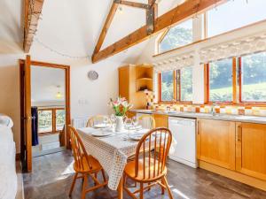 Lanlivery2 Bed in Fowey CHEST的厨房以及带桌椅的用餐室。