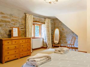 Lanlivery2 Bed in Fowey CHEST的一间卧室配有一张床、一个梳妆台和一扇窗户。