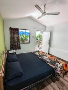 阿姆波尔Nature of Arambol的一间卧室配有一张大床和吊扇