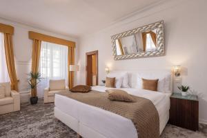 捷克克鲁姆洛夫Bellevue Hotel Český Krumlov的卧室配有一张白色大床和镜子