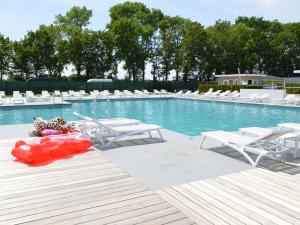 贝梅伦Resort Mooi Bemelen 8的一个带白色椅子和红色浮子的游泳池