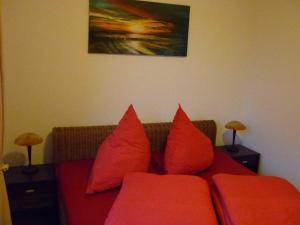 卡尔斯哈根Fewo Wiesenblick_MEYH的客厅里红色的沙发,配有红色枕头