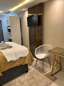 恩潘盖尼Le Rosette Residence的一间卧室配有一张床、一把椅子和一张桌子