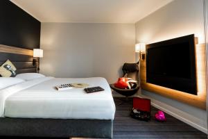 格拉斯哥Moxy Glasgow SEC的配有一张床和一台平面电视的酒店客房