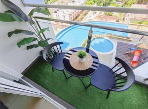 Kota BharuSkyHome @ D'Perdana Kota Bharu的一个带桌椅的阳台和一个游泳池