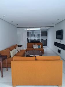 拉巴特Villa de ville的客厅配有橙色沙发和电视