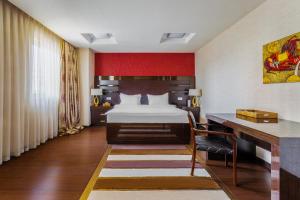塔什干达尔罕精品酒店的酒店客房配有一张床、一张书桌和一张书桌。