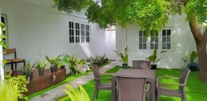 达拉万度Turtle Inn Dharavandhoo的庭院配有桌椅和植物