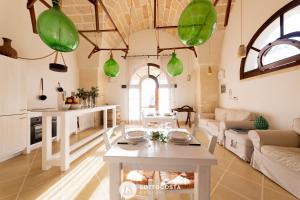 莱切省卡瓦利诺Masseria Tenuta Le Menze的客厅配有桌子和绿色吊灯