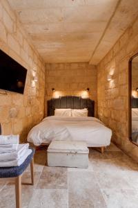 卢加Talbot House by Talbot & Bons的卧室配有一张石墙床