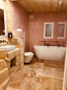 卢加Talbot House by Talbot & Bons的带浴缸、卫生间和盥洗盆的浴室