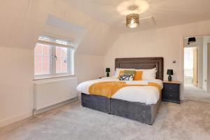 大邓莫Kestrel Gardens Dunmow的一间卧室设有一张大床和一个窗户。