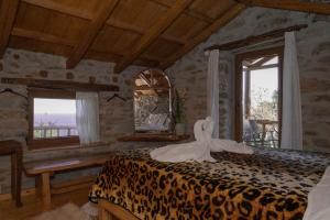 MakrirrákhiAristoteli's Stone House的一间卧室配有一张带镜子的豹纹床
