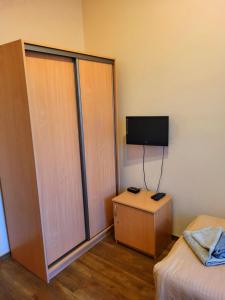 戈莱纽夫Hostel na Fali的一间带一张床和电视的房间以及一间带沙发床的房间