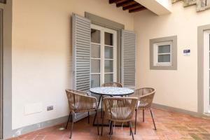 佛罗伦萨numa I Felice Rooms & Apartments的一个带桌椅的庭院和一个窗户。